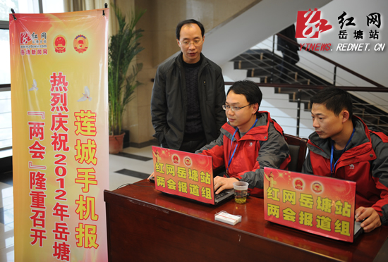 伍石元在岳塘新闻网"两会"特别报道组工作台前浏览新闻