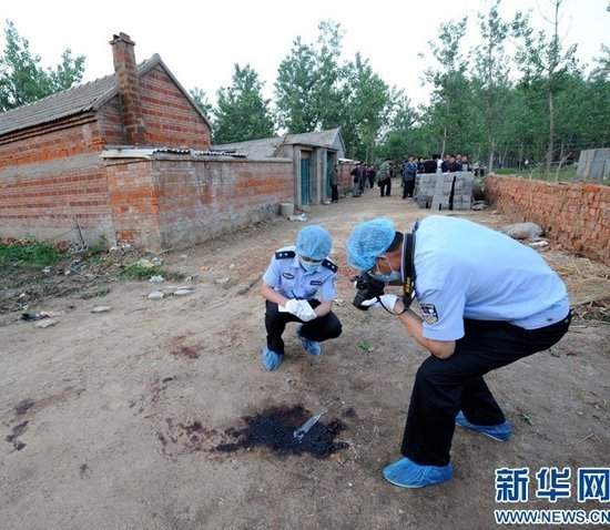 5月27日,警察在案发现场(图左院落)附近勘查.